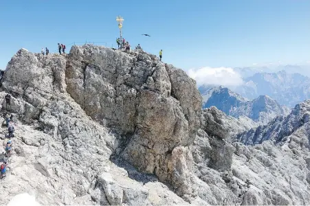  ?? RICK STEVES ?? A golden cross marks the top of the Zugspitze — the highest point in Germany.