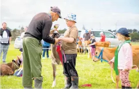  ?? ?? Max Charmley presents the Charmley Cup to Bryce Feetham for his champion calf.