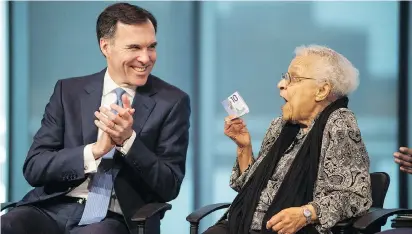  ?? DARREN CALABRESE/THE CANADIAN PRESS ?? Wanda Robson holds the $10 bill featuring her sister while joking with Finance Minister Bill Morneau. His latest federal budget is long on political messaging, Mischa Kaplan says.