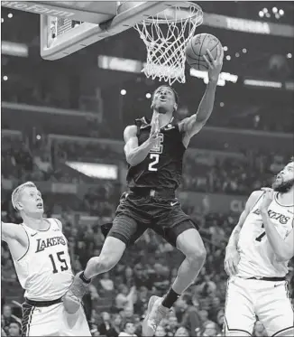  ?? Mark J. Terrill Associated Press ?? CLIPPERS GUARD Shai Gilgeous-Alexander shoots as the Lakers’ Moe Wagner, left, and JaVale McGee defend during the first half Friday night. The Lakers won 122-117.