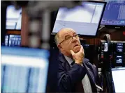  ?? RICHARD DREW / ASSOCIATED PRESS ?? Trader Frederick Reimer works the New York Stock Exchange floor Wednesday. Markets began the day with a tumble, as lackluster Chinese economic data revived fears a trade war imperils growth.