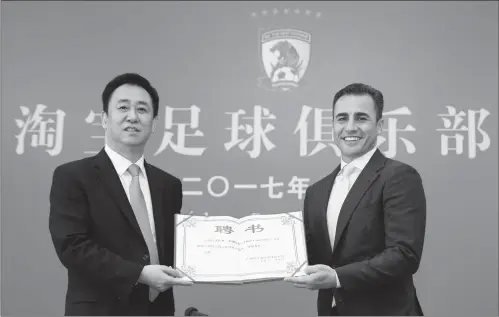  ??  ?? New Guangzhou Evergrande coach Fabio Cannavaro (right) poses for photograph­s with Evergrande boss Xu Jiayin on Thursday in Guangzhou, Guangdong Province.