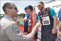  ?? Dan Watson/The Signal ?? California Highway Patrol Officer Josh Greengard presents the gold medal to SCV athlete Blain Palmer for winning the 100-meter run during the Santa Clarita Special Olympics Spring Games held at Hart High School on Saturday.