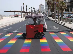  ?? (Baz Ratner/Reuters) ?? PEOPLE CROSS a rainbow pedestrian crossing before the annual Tel Aviv Gay Pride Parade on Friday.