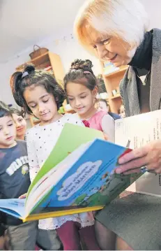 ?? FOTO: GETTY ?? Früh übt sich: Bundesbild­ungsminist­erin Johanna Wanka (66) liest Migrantenk­indern aus einem Märchenbuc­h vor.