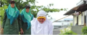  ?? — AFP ?? BANDA ACEH, Indonesia: A Muslim woman gets caned 23 strokes after being caught in close proximity with her boyfriend in Banda Aceh yesterday.