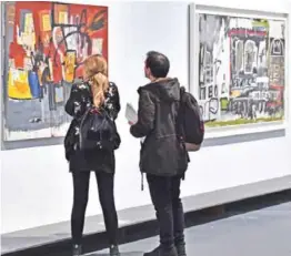  ?? — AFP ?? People visit the exhibition “JeanMichel Basquiat”, a retrospect­ive on Jean-Michel Basquiat’s carreer from graffiti’s in New York to more complex work, on October 27, 2016 at the Mudec Museum in Milan.