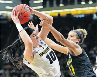  ?? [CHARLIE NEIBERGALL/THE ASSOCIATED PRESS] ?? Iowa’s Megan Gustafson catches a pass as Missouri’s Cierra Porter defends during Sunday’s NCAA Tournament game.