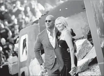  ?? Valerie Macon AFP/Getty Images ?? THE FILM cost about $120 million to produce. Above, Dwayne Johnson and Malin Akerman at the premiere.