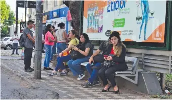  ?? ?? Varios usuarios del transporte público aguardan la llegada de buses en una parada en mal estado.