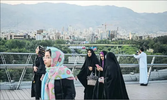  ?? ALI MOHAMMADI / BLOOMBERG ?? Paseantes en el puente de Tabiat, en Teherán, el pasado sábado al atardecer