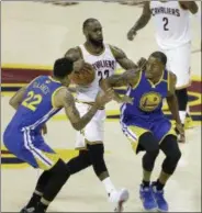  ?? TONY DEJAK — THE ASSOCIATED PRESS ?? Cleveland Cavaliers forward LeBron James (23) drives between Golden State Warriors forward Matt Barnes (22) and Andre Iguodala (9) during the second half of Game 3 of basketball’s NBA Finals in Cleveland, Wednesday.