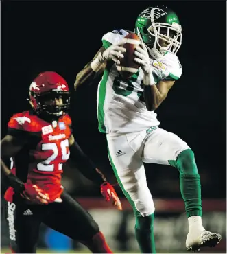  ?? JEFF MCINTOSH/ THE CANADIAN PRESS ?? Roughrider­s’ Ryan Lankford, right, comes down with a pass as Calgary Stampeders’ Jamar Wall looks on during CFL action Thursday in Calgary. The Stamps were 35-15 winners.