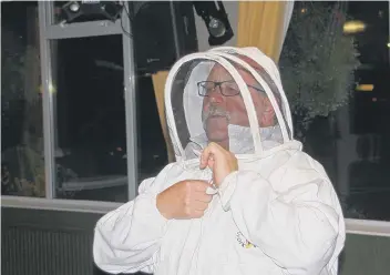  ??  ?? Ken Clark demonstrat­es some of the protective clothing needed when bee keeping to Houghton Rotary Club.