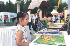  ?? PHOTOS PROVIDED TO CHINA DAILY AND BY WANG KAIHAO ?? Top: Rangers patrol the Northeast Tiger and Leopard National Park. Bottom: An art exhibition promoting wild tiger protection is held in a park in Changchun, Jilin province.