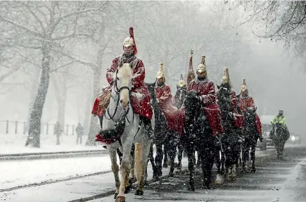  ?? PHOTO: AP ?? Members of the Household Cavalry return to their barracks as snow falls in London yesterday.
