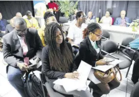  ?? (Photos: Joseph Wellington) ?? Shareholde­rs look over the annual report at an AGM held by Key Insurance in 2019.