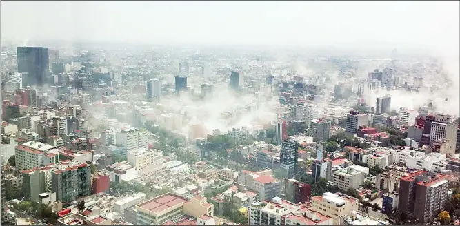  ?? (AP) ?? In this photo provided by Francisco Caballero Gout, shot through a window of the iconic Torre Latina, dust rises over downtown Mexico City during a 7.1 magnitude earthquake on Sept 19. Throughout Mexico City, rescue workers
and residents dug through...