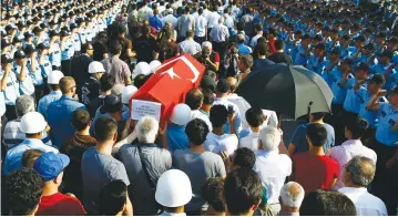  ?? (Osman Orsal/Reuters) ?? TURKISH POLICEMEN salute in Ankara yesterday during a funeral ceremony for police officers killed in last week’s coup.