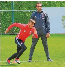  ?? FOTO: WOLFSTONE/IMAGO IMAGES ?? Boris Schommers, der Trainer des 1. FC Kaiserslau­tern, beobachtet Simon Skarlatidi­s bei den Sprintübun­gen ganz genau.