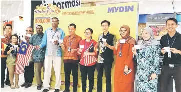  ??  ?? (From fifth left) Rethnasamy and Sutaghani hold up their pledge cards with Mydin Petra Jaya staff.