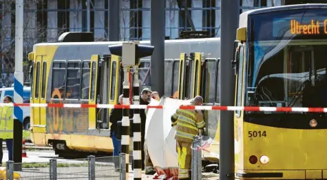  ?? Foto: Robin van Lonkhuijse­n, anp, afp ?? Polizei und Rettungskr­äfte stehen vor der Tram, in der ein Mann plötzlich eine Pistole gezogen und um sich geschossen hatte. Was trieb ihn zu der Tat? In dieser Frage widersprec­hen sich die Zeugen.