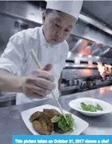  ??  ?? This picture taken on October 31, 2017 shows a chef preparing a dish of fried pork liver at the Hsin Yeh restaurant in Taipei. —AFP photos