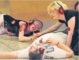  ??  ?? ‘Victims’ covered with fake blood in the Trafford terror drill yesterday