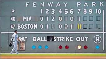  ?? CHARLES KRUPA/AP PHOTO ?? Miami Marlins left fielder Austin Dean walks back to his position during an 11-run seventh inning that rallied the Red Sox to a 14-6 victory on Wednesday night at Fenway Park in Boston.