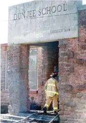  ?? PHOTO BY PAUL B. SOUTHERLAN­D, THE OKLAHOMAN ?? An Oklahoma City firefighte­r enters the vacant Dunjee School after a fire Tuesday.
