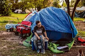  ?? ?? Bryan Huntley, 11, sits outside his tent in Riverside Park in Grants Pass after getting in a fight with one of his sisters.