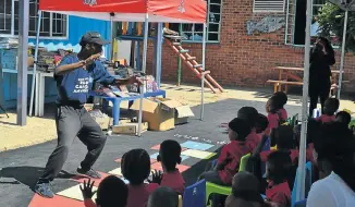  ??  ?? POWER OF WORDS: Story sparker Sello Mabaso retells an exciting tale to preschoole­rs at the book donation handover