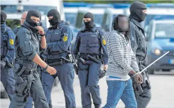  ?? FOTO: DPA ?? Polizeiein­satz in der Landeserst­aufnahmeei­nrichtung für Flüchtling­e in Ellwangen: Ein gefesselte­r Mann wird von maskierten Polizisten abgeführt.