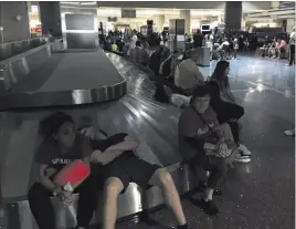  ?? Michael Quine ?? Las Vegas Review-journal Passengers at baggage claim wait for the power to be restored Wednesday at Mccarran Internatio­nal Airport.