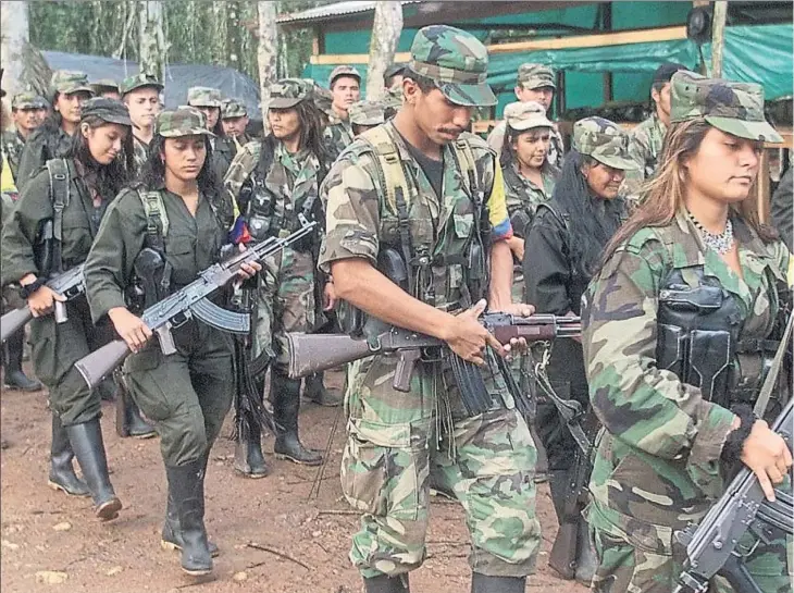  ??  ?? Marxa en un camp de guerriller­s de les FARC en un lloc indetermin­at de la jungla del sud de Colòmbia el juny del 2001