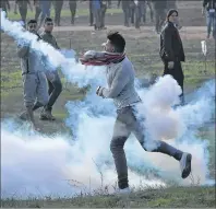  ?? AP PHOTO ?? A Palestinia­n protester throws back a teargas canister that was fired by Israeli soldiers Friday during clashes on the Israeli border following a protest against U.S. President Donald Trump’s decision to recognize Jerusalem as the capital of Israel,...