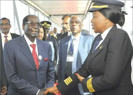  ?? — (Picture by Presidenti­al Photograph­er Joseph Nyadzayo) ?? President Mugabe greets Air Zimbabwe Captain Chipo Matimba who was leading the first all-female crew to fly him in an Airbus A320 from Mauritius yesterday. The other crew members are First Officer Sithandeki­le Dube and Senior Flight attendants...