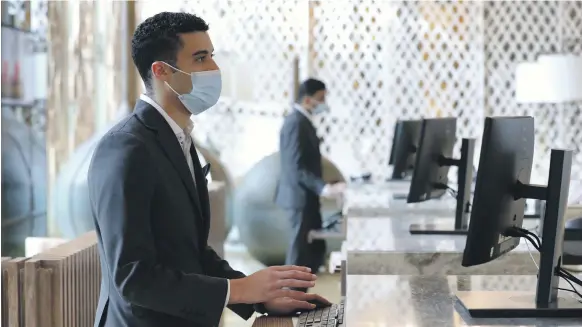  ?? Chris Whiteoak / The National ?? Staff at Al Jaddaf Rotana in Dubai check in guests. Companies operating in travel and tourism have been hard hit by the pandemic