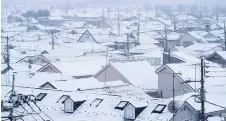  ?? — AFP file photo ?? Photo shows roofs of houses covered with snow in Tokyo.