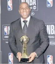  ?? RICHARD SHOTWELL/INVISION ?? Earvin“Magic”Johnson holds a lifetime achievemen­t award at the NBA Awards in 2019.