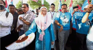  ??  ?? Big welcome: Dr Wan Azizah arriving to hand in her papers for the Pandan seat. Below: Barisan supporters giving their full backing in Pekan.