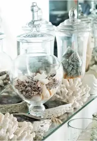 ??  ?? Oben Die Glassammlu­ng, gefüllt mit Muscheln vom Strand, ziert ein ganzes Regal im Wohnzimmer. Rechts Geschirr und Küchenuten­silien mit maritimem Dekor sind ein Muss!