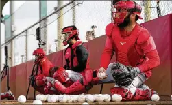  ?? AP 2023 ?? The knee-down catching technique is taught at Reds camp Feb. 17. Robo umps can’t be influenced when catchers try making borderline pitches look like strikes.