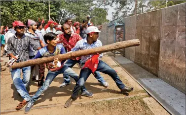  ?? REUTERS ?? Supporters of the Communist Party of India-Marxist try to break a police barricade during a rally demanding pricing reforms in the agricultur­e sector, in Kolkata on Monday.