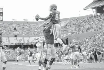  ?? BRAD MCCLENNY/ASSOCIATED PRESS ?? Florida tight end Kyle Pitts leaps as he celebrates a touchdown catch with teammates during an SEC game against South Carolina on Saturday in Gainesvill­e, Florida. The Gators beat the Gamecocks 38-24.