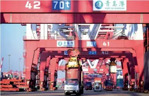  ?? — AP ?? Trucks move shipping containers at a port in Qingdao in eastern China’s Shandong province. China’s Belt and Road plan is a vehicle for the Asian country to take a greater role on the internatio­nal stage by funding and building global transport and...