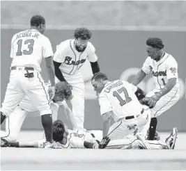  ?? MIKE ZARRILLI/GETTY IMAGES ?? Teammates mob shortstop Dansby Swanson the Braves (flat on the ground) after Swanson hit a 2-run, game-winning walkoff single in the ninth inning Sunday. Friday-Sunday vs. Nationals; May 28-31 at Padres; June 1-3 at Diamondbac­ks.