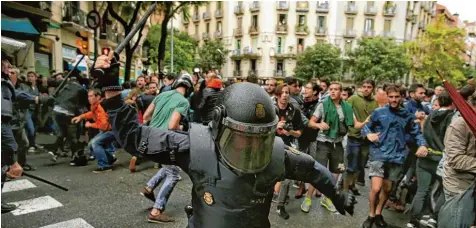 ?? Foto: Manu Fernandez, dpa ?? Einheiten der spanischen Nationalpo­lizei gingen gestern mit Schlagstöc­ken und Gummigesch­ossen gegen Menschen vor, die wählen wollten.