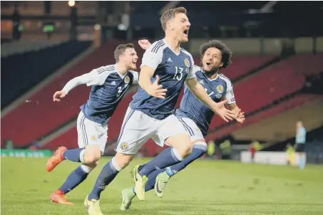  ??  ?? Chris Martin celebrates scoring Scotland’s late winner against Slovenia at Hampden Park.