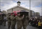  ?? EFREM LUKATSKY — THE ASSOCIATED PRESS ?? People kneel as servicemen carry the coffins of four Ukrainian soldiers during a commemorat­ion ceremony in Independen­ce Square in Kyiv, Ukraine, on Tuesday. The servicemen's names are Bohdan Legov, 19, Maksym Mykhailov, 32, Yuri Horobets, 34, and Taras Karpiuk, 36.